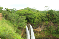 Wailua Falls plunging into a lush tropical canyon.